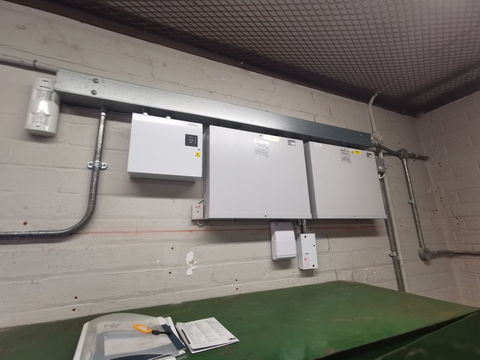 Wall-mounted electrical distribution boards, trunking and pipework in a lower room